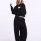 Modelo de cuerpo entero con sudadera negra Cold Culture Berry vista frontal con gráfico de cerezas rosas en el pecho