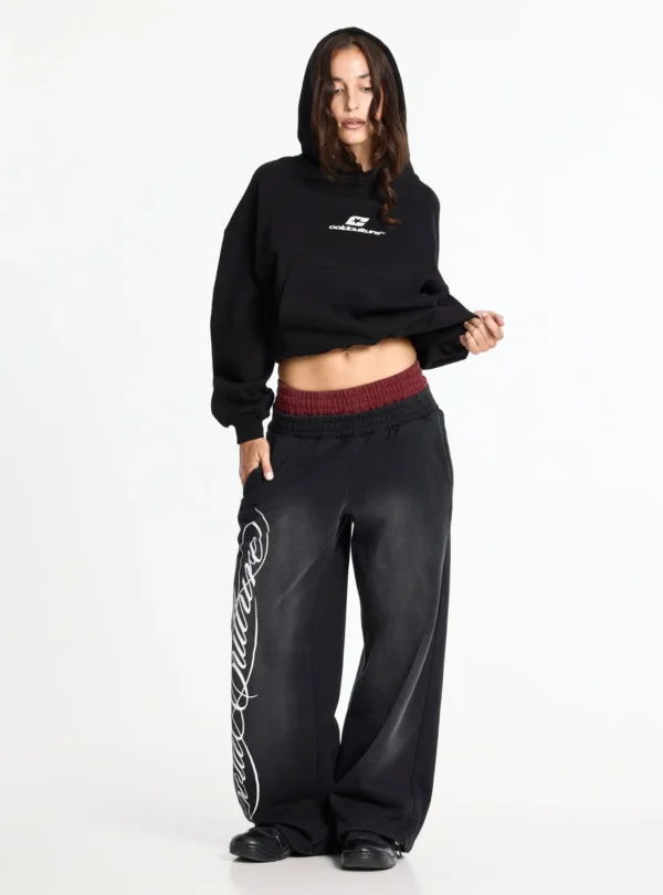 Modelo con sudadera negra Cold Culture Tartan Curved Hoodie, capucha puesta, logo blanco y bolsillo canguro