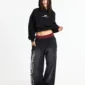 Modelo con sudadera negra Cold Culture Tartan Curved Hoodie, capucha puesta, logo blanco y bolsillo canguro
