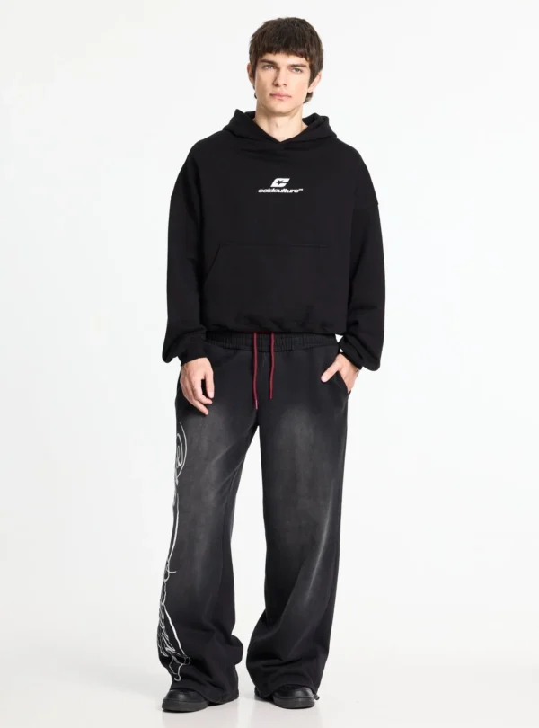 Modelo con sudadera negra Cold Culture Tartan Curved Hoodie, logo blanco en el pecho y bolsillo canguro