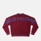 Vista trasera del jersey Archive Gothic Knit Red de Cold Culture en rojo burdeos, con letras góticas azules de gran tamaño en la espalda y ribetes a rayas azules.