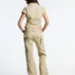 Modelo de espaldas con pantalones cargo Army Script de Cold Culture en verde militar, de pernera ancha y bolsillos traseros con correas.