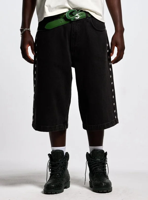 Modelo con shorts Badges Jorts de Cold Culture en Black Licorice, mostrando el ajuste holgado y los detalles laterales