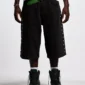 Modelo con shorts Badges Jorts de Cold Culture en Black Licorice, mostrando el ajuste holgado y los detalles laterales