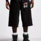 Modelo con shorts Badges Jorts de Cold Culture en Black Licorice, vista trasera con parches gráficos en el bolsillo