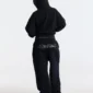 Modelo de espaldas con la sudadera negra Bling de Cold Culture para mujer, mostrando la capucha puesta y el corte holgado posterior.