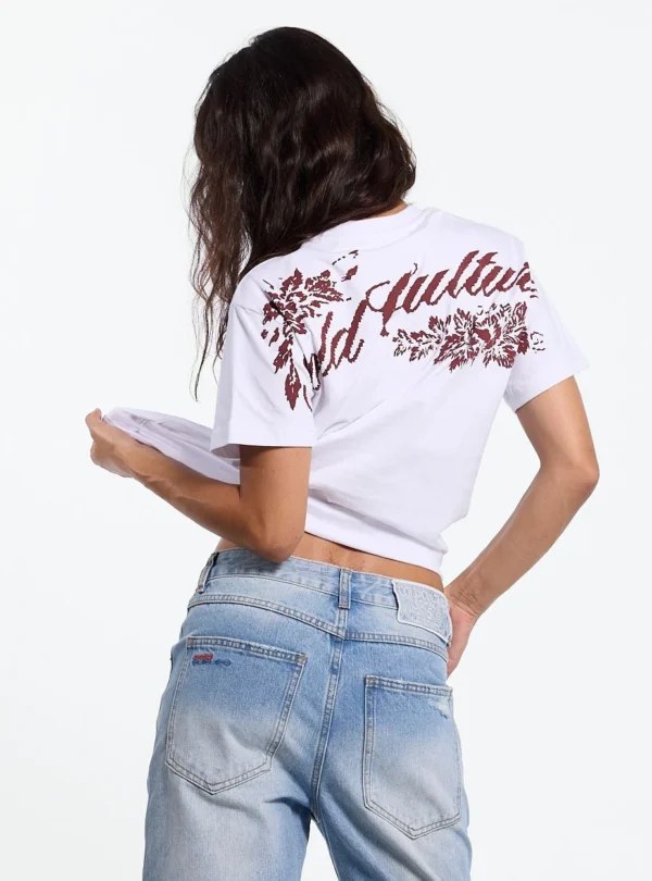 Modelo con camiseta blanca Cold Culture Bloom mostrando el gran gráfico floral y logotipo en la espalda