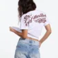 Modelo con camiseta blanca Cold Culture Bloom mostrando el gran gráfico floral y logotipo en la espalda