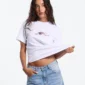 Modelo con camiseta blanca Cold Culture Bloom y gráfico floral pequeño en el pecho