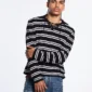 Vista cercana del modelo con jersey negro Cold Culture Breakout Knit de rayas blancas y cuello con cordones