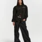 Modelo de cuerpo entero con la camisa Brick Lane de Cold Culture en color Black Square, combinada con pantalones negros de rayas verticales