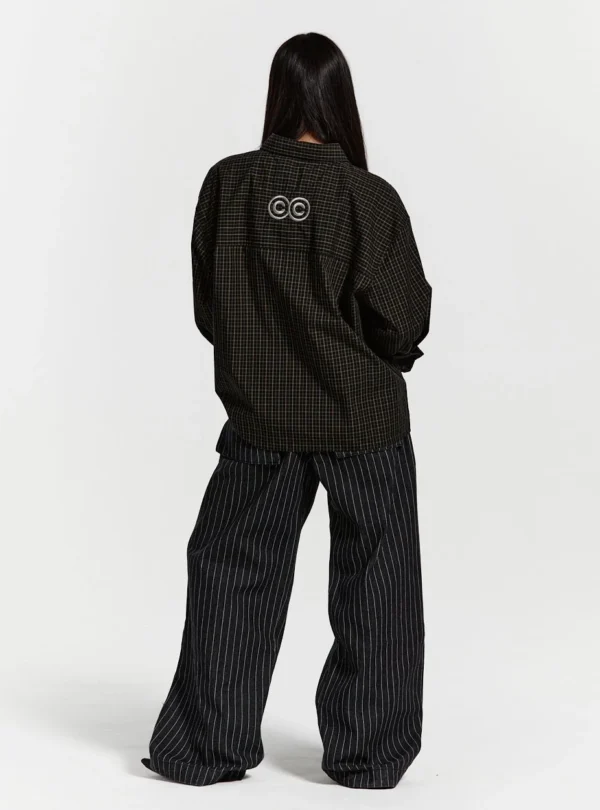 Modelo de cuerpo entero de espaldas con la camisa Brick Lane de Cold Culture en color Black Square, mostrando el logotipo de doble C y el corte holgado