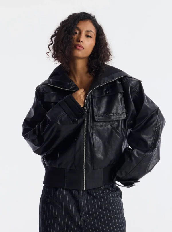 Modelo con el abrigo negro Bunker Bomber de Cold Culture, cuello ancho abierto, bolsillos delanteros y logotipo bordado en el pecho.