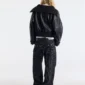 Modelo de espaldas con el abrigo negro Bunker Bomber de Cold Culture, cuello ancho doblado y corte corto con cintura elástica.