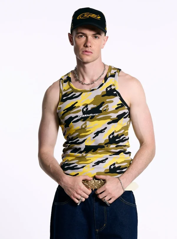 Cold Culture Camo Tank Top – Amarillo – Vista frontal con modelo y gorra Modelo de frente con la camiseta de tirantes Camo Tank Top amarilla de Cold Culture, con estampado de camuflaje y logotipo en el pecho, combinada con gorra negra