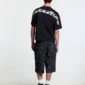Modelo con shorts Casino negros de Cold Culture a rayas y bolsillos traseros, vista posterior