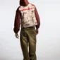 Modelo con abrigo Cold Culture Chipped Camo marrón y camuflaje visto de espaldas, con logotipo rojo