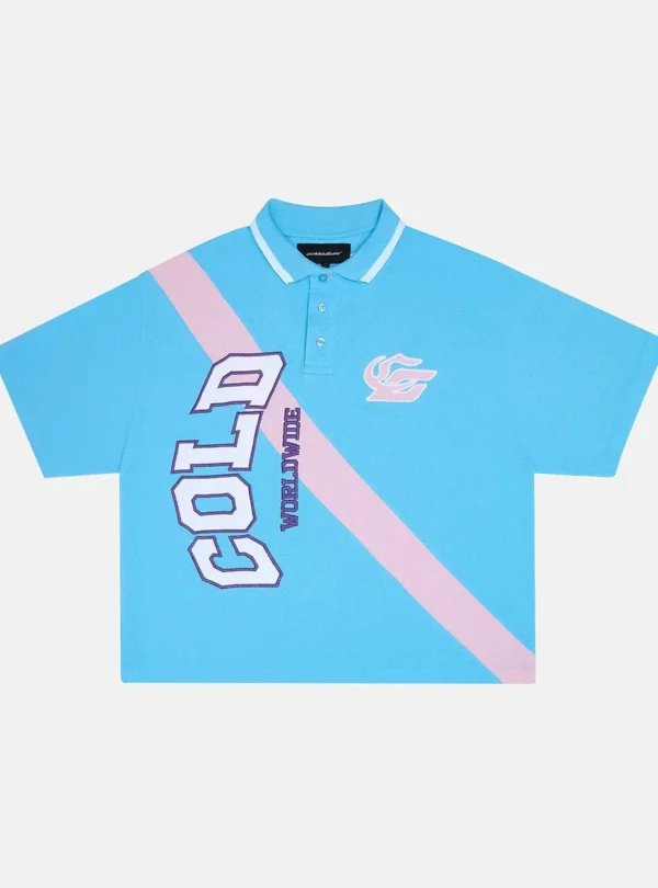 Polo Cocky azul de Cold Culture con franja diagonal rosa, letras grandes en el frontal, cuello con ribete blanco y manga corta.