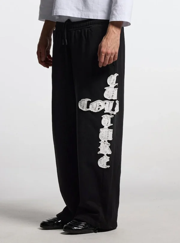 Detalle de los pantalones deportivos negros Cold Culture Crossed con gráfico blanco en la pernera