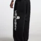 Vista posterior de modelo con pantalones deportivos negros Cold Culture Crossed y gráfico blanco en la pernera