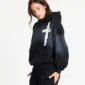 Modelo con sudadera negra Crossed de Cold Culture, capucha, efecto degradado gris, gráfico blanco en forma de cruz y bolsillo canguro.