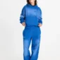 Modelo con sudadera Crossed azul de Cold Culture vista de frente, con corte oversize, bolsillo canguro y cruz en relieve.