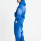 Modelo con sudadera Crossed azul de Cold Culture, vista lateral trasera con capucha y mangas holgadas.