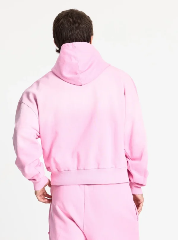 Cold Culture Crossed Sudadera Pink – Detalle de espalda con modelo Modelo de espaldas con la sudadera rosa Crossed de Cold Culture, mostrando la capucha, las mangas amplias y el bajo acanalado.