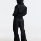 Modelo de espaldas con pantalones deportivos Curve negros de Cold Culture, con pernera ancha y logotipo de la marca en la parte trasera.