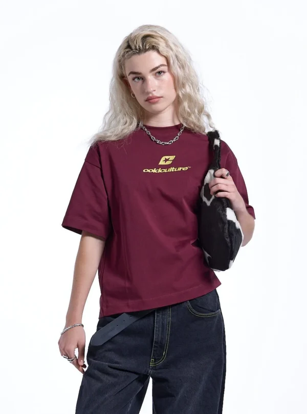 Modelo con camiseta Cold Culture Curved en burdeos y amarillo, vista frontal con logotipo amarillo en el pecho