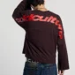 Modelo con la manga larga Cold Culture Curved marrón vista de espaldas, con gráfico rojo de Cold Culture