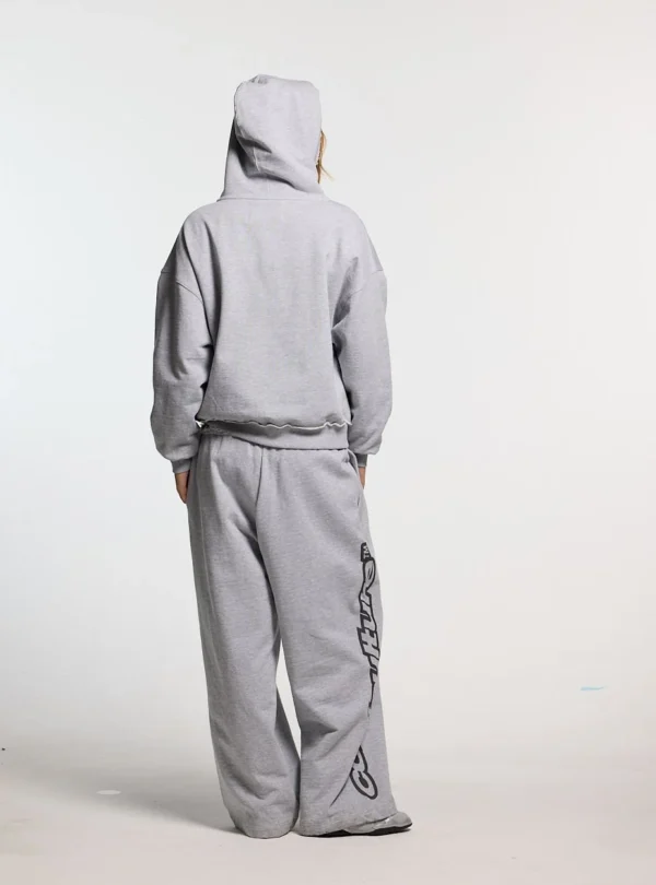 Modelo luciendo los pantalones deportivos Cold Culture Daily Set en Grey Melange desde atrás, mostrando su silueta de pernera ancha