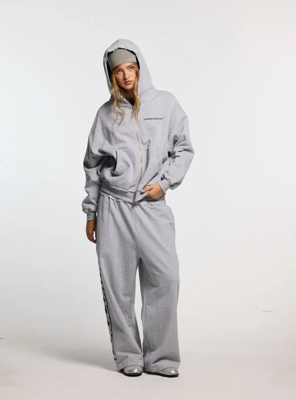Modelo luciendo los pantalones deportivos Cold Culture Daily Set en Grey Melange de frente con corte de pernera ancha