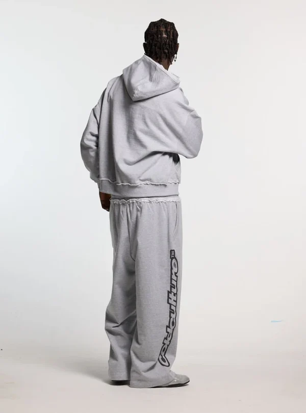 Modelo luciendo los pantalones deportivos Cold Culture Daily Set en Grey Melange desde atrás, con logotipo vertical negro