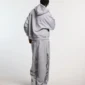 Modelo luciendo los pantalones deportivos Cold Culture Daily Set en Grey Melange desde atrás, con logotipo vertical negro