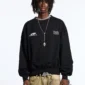 Modelo con sudadera sin capucha negra Cold Culture Defense mostrando los gráficos blancos del pecho