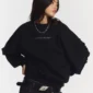 Modelo con sudadera sin capucha Distress Curved de Cold Culture en negro, detalle frontal del logotipo en el pecho y mangas