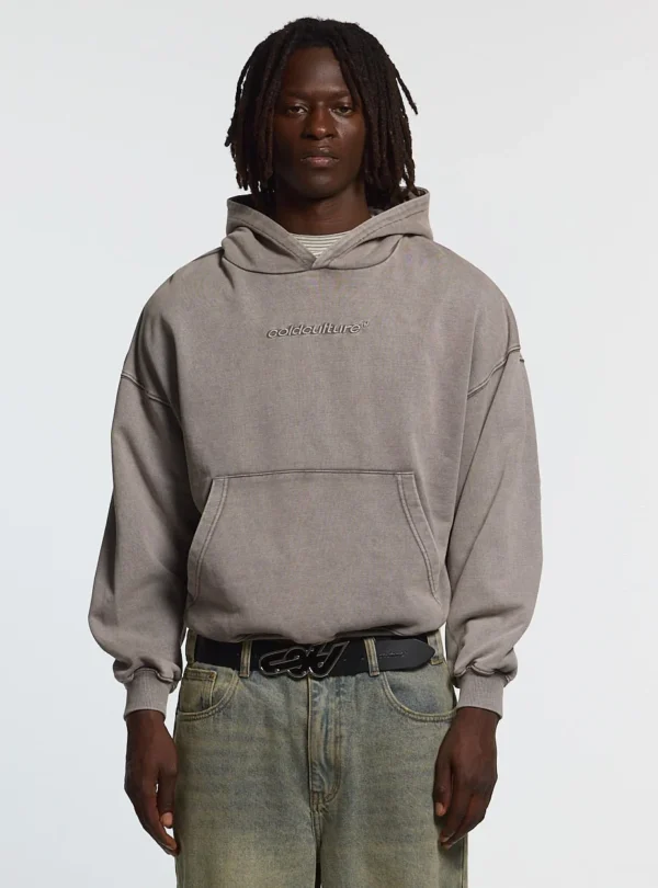 Cold Culture Distress Curved Sudadera – Washed Grey – Modelo de frente Modelo con sudadera Cold Culture Distress Curved en Washed Grey, capucha, logo Cold Culture en el pecho y bolsillo canguro