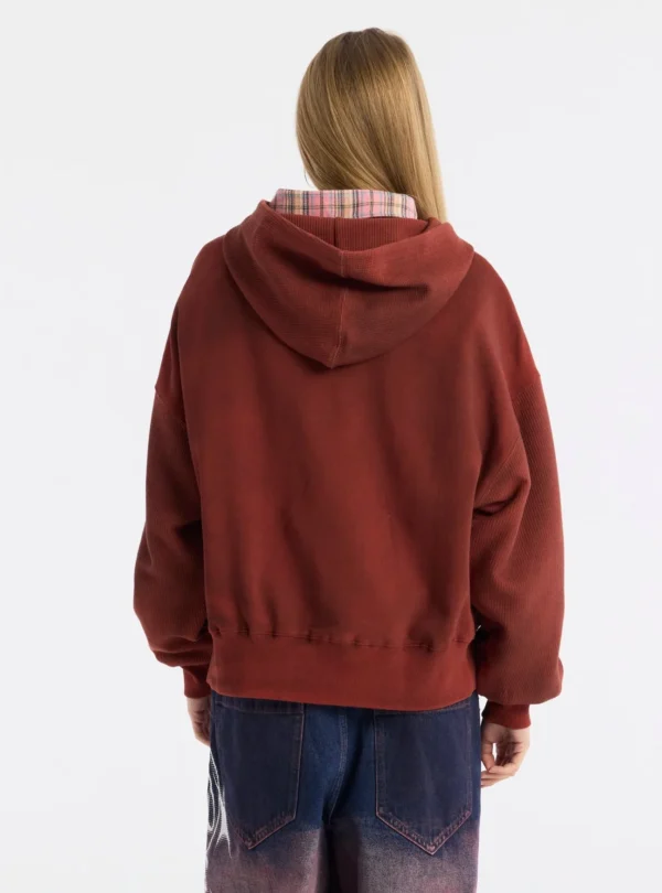 Modelo de espaldas con la sudadera roja Dust 55 de Cold Culture, mostrando su corte holgado, capucha y mangas voluminosas.