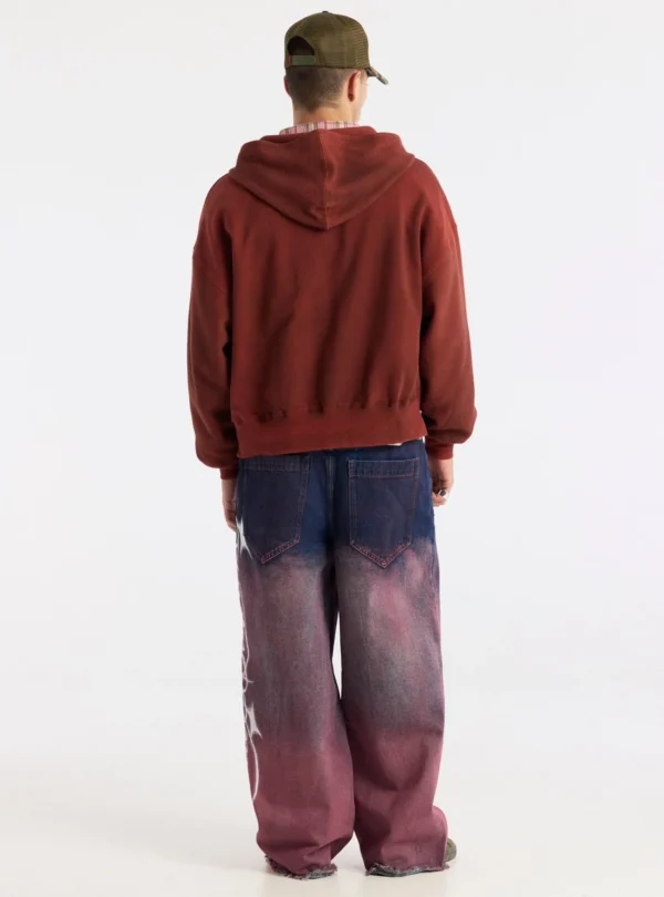 Modelo con gorra visto de espaldas, llevando la sudadera roja Dust 55 de Cold Culture con capucha, hombros caídos y corte holgado.