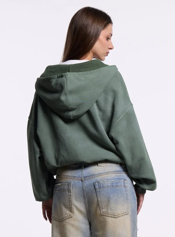 Mujer con sudadera con cremallera verde Eagle de Cold Culture vista desde atrás, con capucha y diseño trasero liso