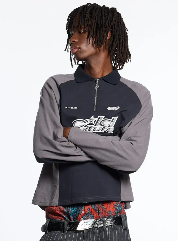 Modelo con polo Extreme Longsleeve Polo gris de Cold Culture, con brazos cruzados, cuello con cremallera, mangas en contraste y logotipo blanco en el pecho.