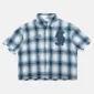 Vista frontal de la camisa Farm de Cold Culture en blanco y cuadros azules, con manga corta, cierre de botones, parches bordados y bajo deshilachado