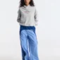 Modelo de cuerpo entero con sudadera Fourth Of July de Cold Culture en gris jaspeado y pantalones azules, mostrando el ajuste holgado, el bolsillo canguro y el estampado frontal.