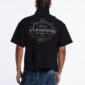 Modelo de espaldas vistiendo el Gilded Polo negro de Cold Culture, con un gran estampado ornamental gris y letras Cold Culture Worldwide Club 2021.