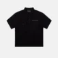 Gilded Polo negro de Cold Culture visto de frente, con cuello clásico, dos bolsillos de solapa con botón y logotipo en el pecho.