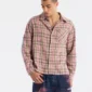 Modelo con camisa Gleenwood Plaid Tartan rosa de Cold Culture, mostrando el estampado de cuadros, el cierre de botones y el bolsillo del pecho.
