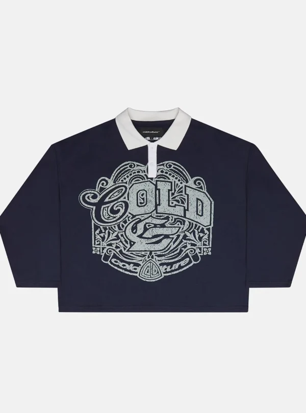 Good Boy Polo de Cold Culture en azul oscuro, con cuello blanco, manga larga y gran estampado gráfico gris en la parte delantera.