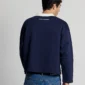 Modelo de espaldas con el Good Boy Polo de Cold Culture en azul oscuro, mostrando el corte holgado y el pequeño logotipo blanco en la parte superior.