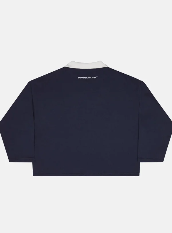 Vista trasera del Good Boy Polo de Cold Culture en azul oscuro, con cuello blanco y pequeño logotipo de la marca bajo el cuello.